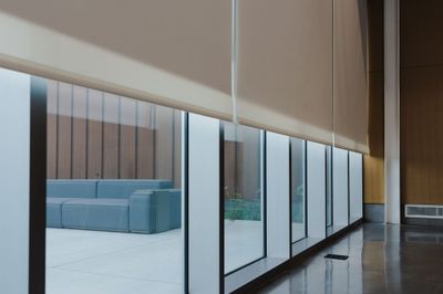Roller shade along a glass wall
